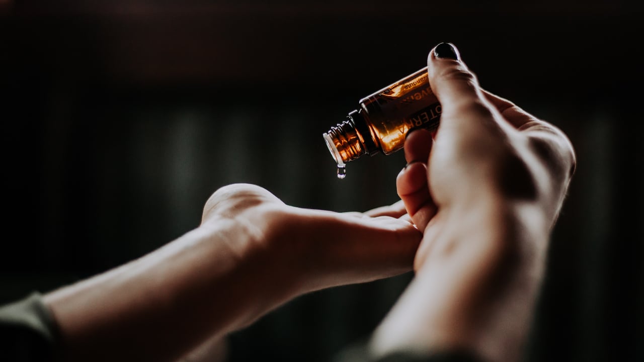 Photo of message oil dripping from a bottle into a hand