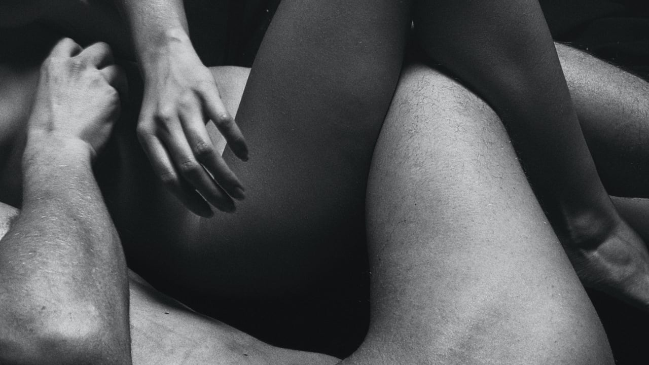 Photo of a woman and man’s legs interlocked