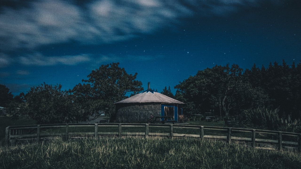 Photo of a small hut on hill at night