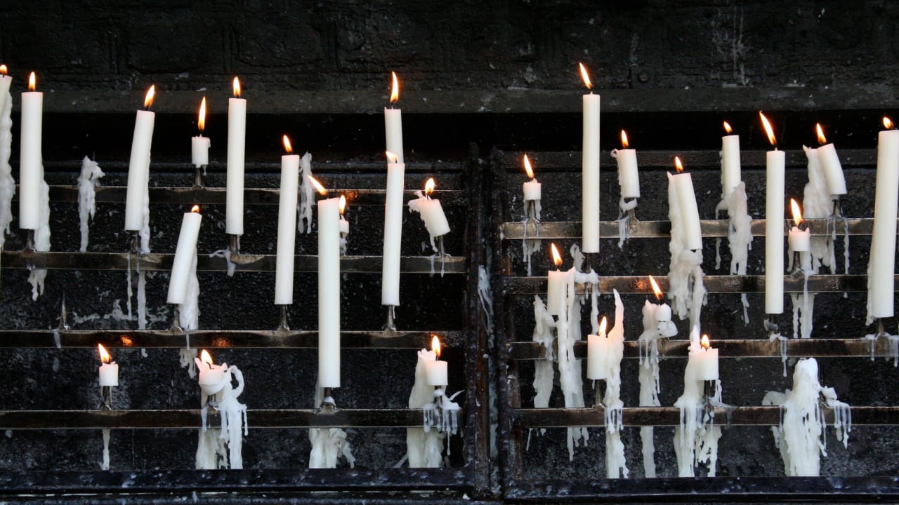 Photo of burning candles on a shelf
